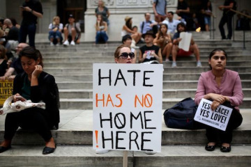 NEW YORK, USA - AUGUST 14 : A protester holds a banner reading "Hate Has No Home Here" during a rally against U.S. President Donald J. Trump for threating North Korea and Venezuela with attacking next to Trump Tower in Manhattan borough of New York, United States on August 14, 2017. (Photo by Mohammed Elshamy/Anadolu Agency/Getty Images)