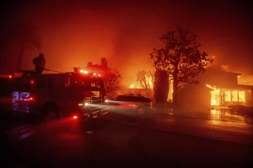 Fire crews battle the Palisades Fire as it burns multiple structures in the Pacific Palisades neighborhood of Los Angeles, Tuesday, Jan. 7, 2025. (AP Photo/Ethan Swope)